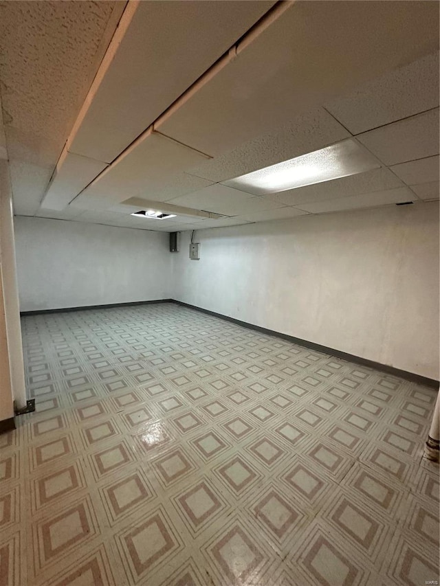 basement with a paneled ceiling