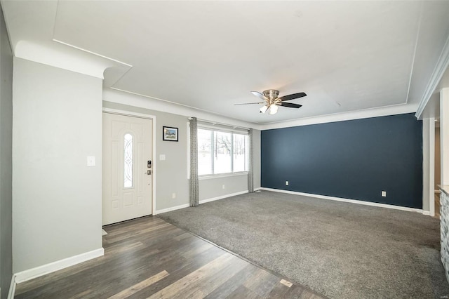 foyer with crown molding, ceiling fan, and dark wood-type flooring