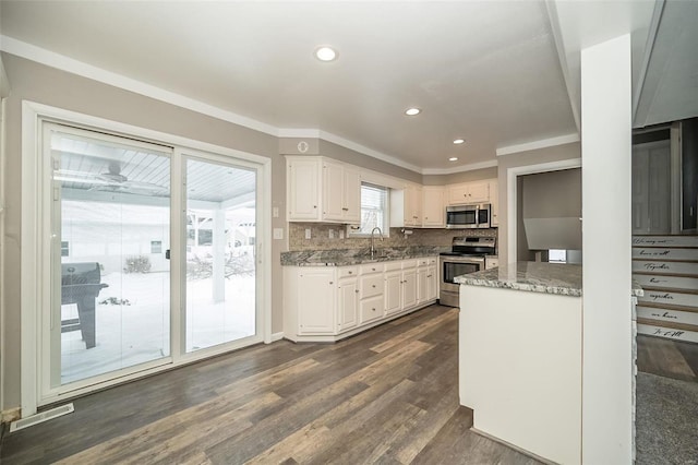 kitchen featuring white cabinets, appliances with stainless steel finishes, stone counters, and sink