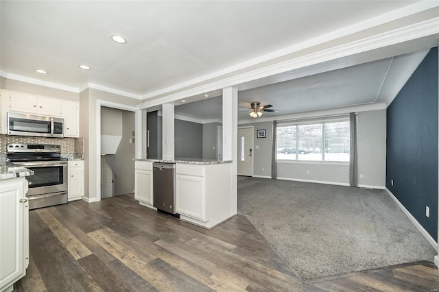 kitchen with backsplash, dark carpet, stainless steel appliances, ceiling fan, and white cabinets