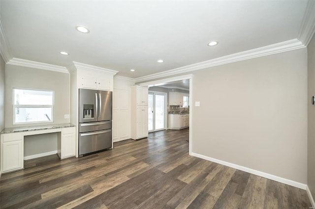 kitchen with dark hardwood / wood-style floors, stainless steel fridge, white cabinetry, and ornamental molding