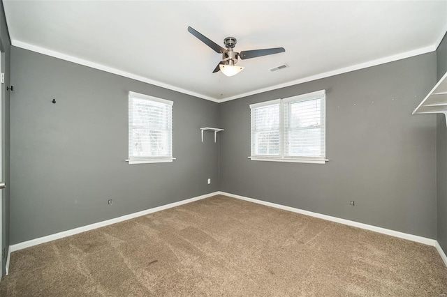 carpeted empty room with ceiling fan and ornamental molding