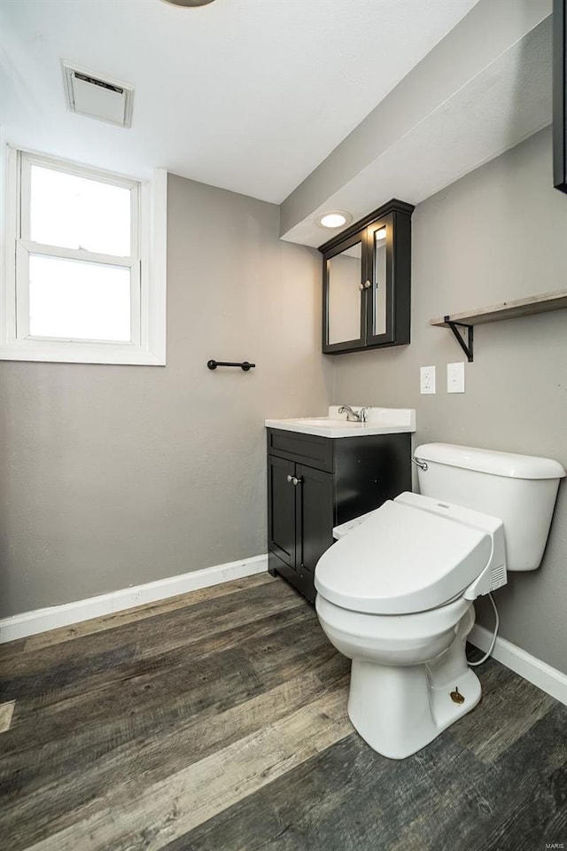 bathroom with hardwood / wood-style floors, vanity, and toilet