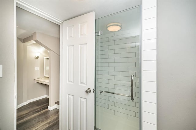 bathroom featuring hardwood / wood-style floors and a shower with door