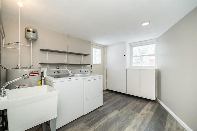 laundry room with washer and dryer, dark hardwood / wood-style floors, electric water heater, and sink