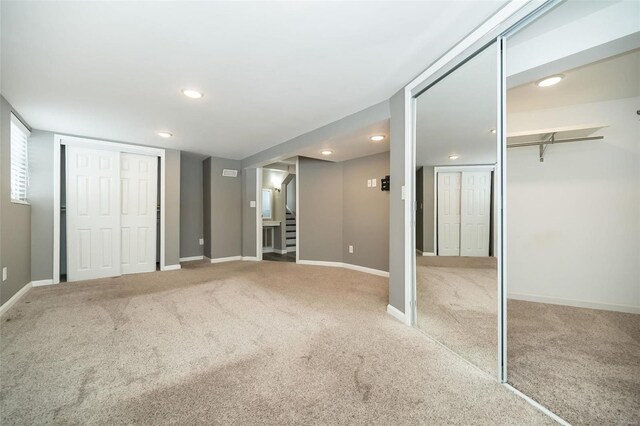 unfurnished bedroom featuring carpet and multiple closets