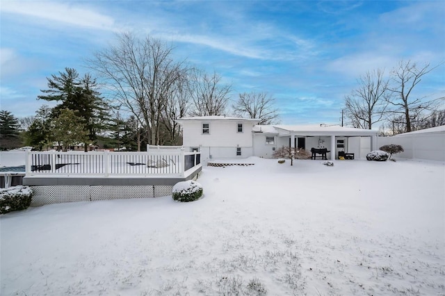 snow covered property featuring a wooden deck