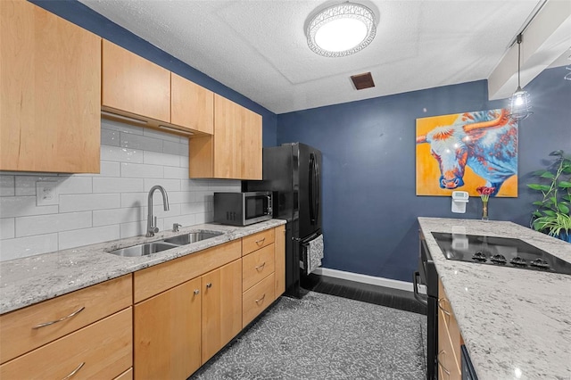 kitchen with baseboards, a sink, stainless steel microwave, black electric stovetop, and backsplash