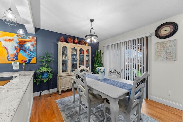 dining room featuring baseboards and light wood-style floors