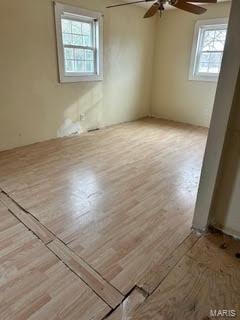 spare room featuring light hardwood / wood-style floors, a wealth of natural light, and ceiling fan