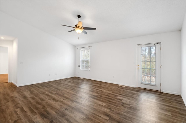 spare room with ceiling fan, a healthy amount of sunlight, and dark hardwood / wood-style floors