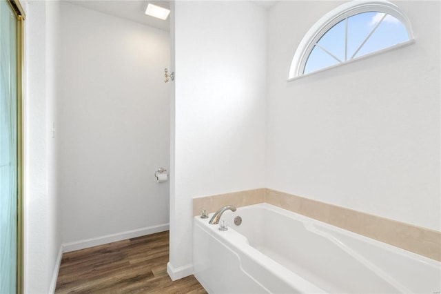 bathroom with hardwood / wood-style floors and a tub