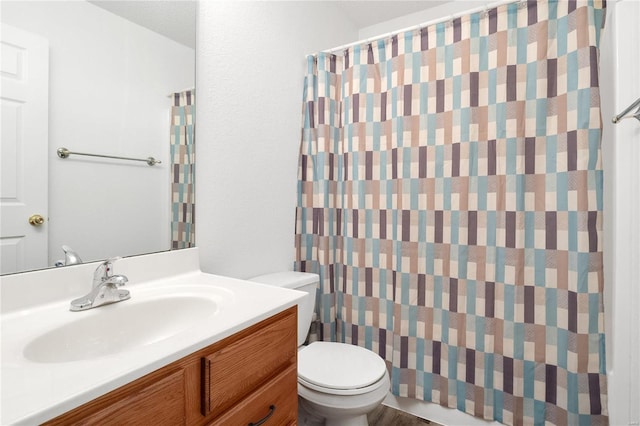 bathroom featuring a shower with curtain, vanity, toilet, and a textured ceiling