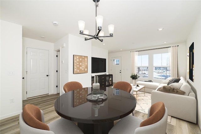 dining area with a chandelier, baseboards, light wood-style flooring, and recessed lighting