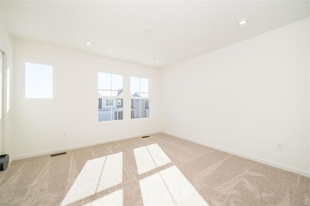 carpeted empty room featuring recessed lighting, visible vents, and baseboards