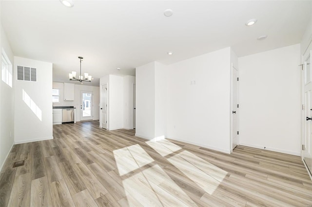 unfurnished living room featuring light wood-style floors, recessed lighting, a chandelier, and visible vents