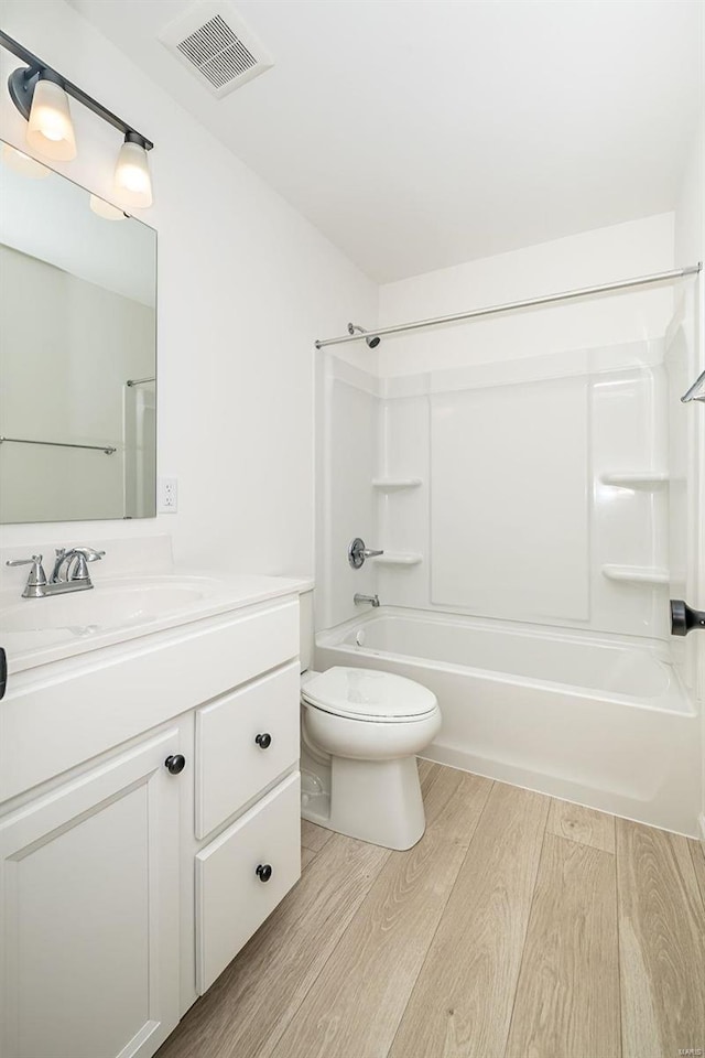 full bathroom featuring visible vents, toilet, tub / shower combination, vanity, and wood finished floors