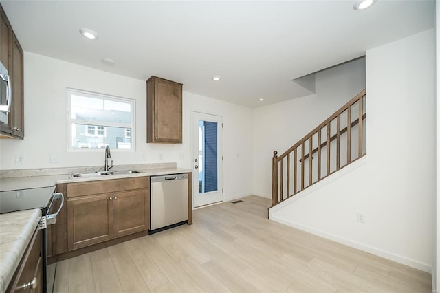 kitchen with light hardwood / wood-style floors, sink, and stainless steel appliances