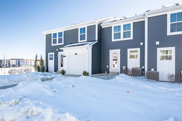 view of front of home with central air condition unit and a garage