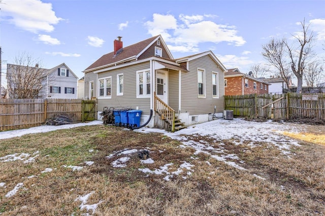 snow covered rear of property with central AC