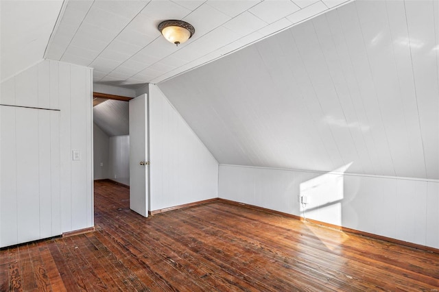 additional living space with dark wood-type flooring and lofted ceiling