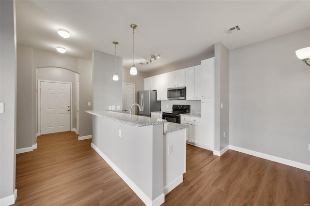 kitchen with white cabinets, stainless steel appliances, hanging light fixtures, and hardwood / wood-style flooring