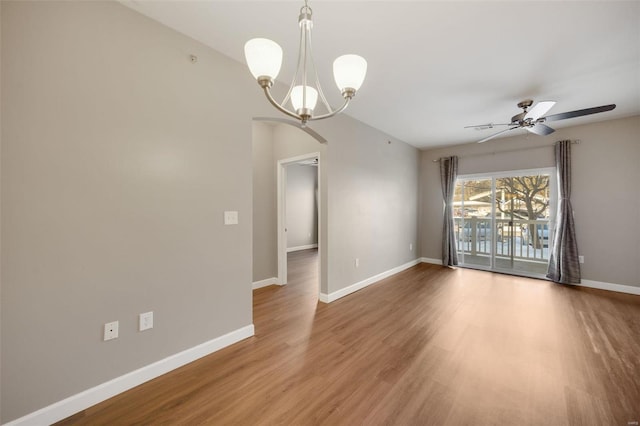 spare room featuring hardwood / wood-style flooring and ceiling fan with notable chandelier