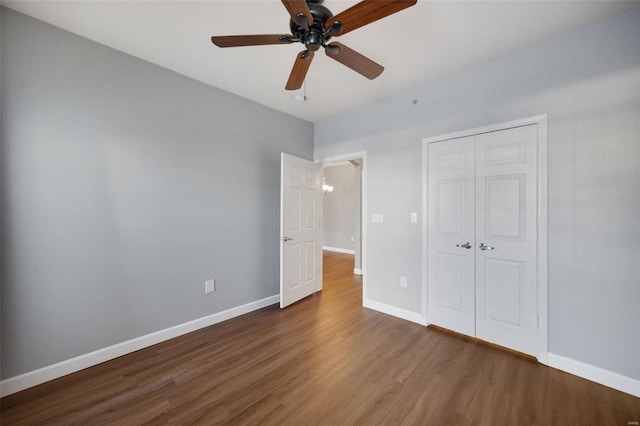 unfurnished bedroom featuring ceiling fan, dark hardwood / wood-style floors, and a closet