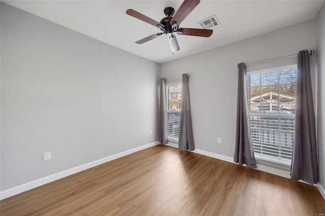 empty room with hardwood / wood-style floors and ceiling fan