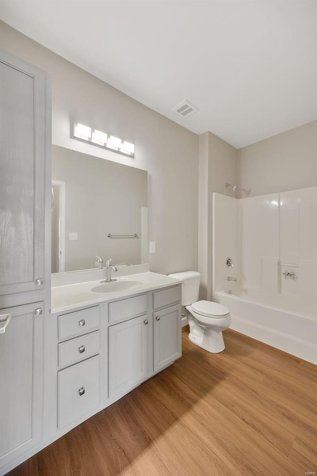 full bathroom featuring vanity, toilet, wood-type flooring, and bathtub / shower combination