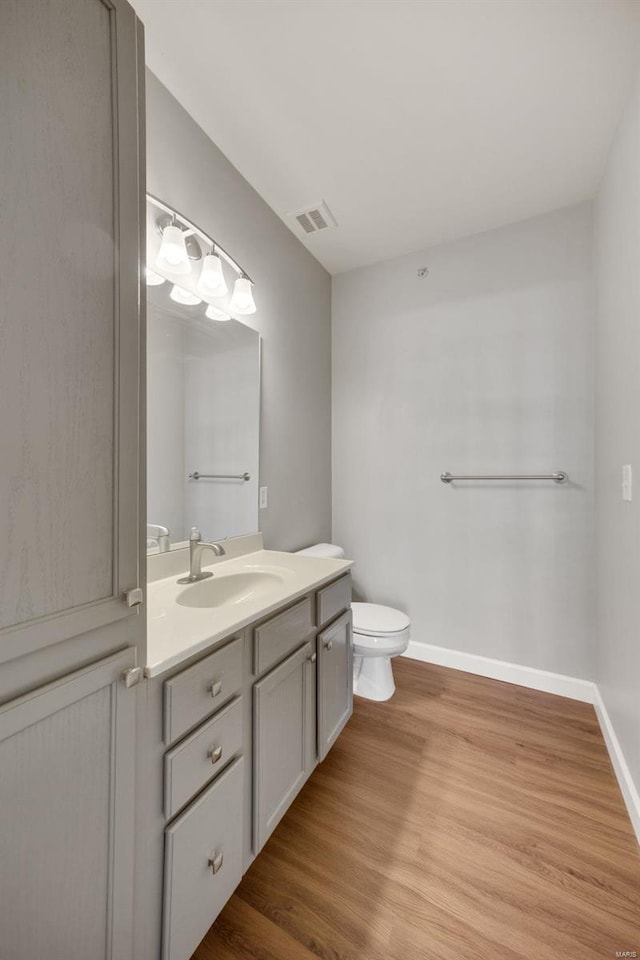 bathroom with vanity, wood-type flooring, and toilet