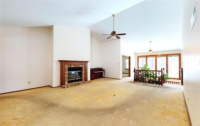 carpeted living room featuring ceiling fan, lofted ceiling, and a brick fireplace