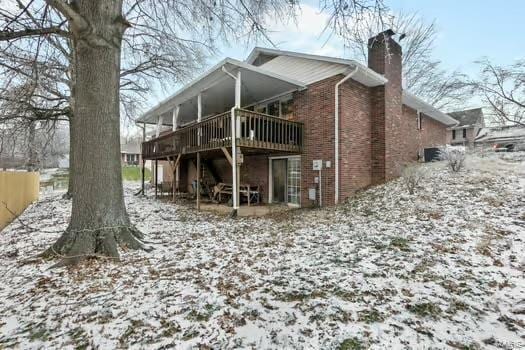 snow covered house with a deck