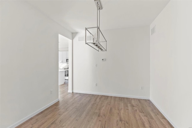 unfurnished dining area featuring light wood-type flooring