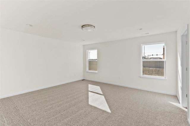 carpeted spare room featuring a healthy amount of sunlight