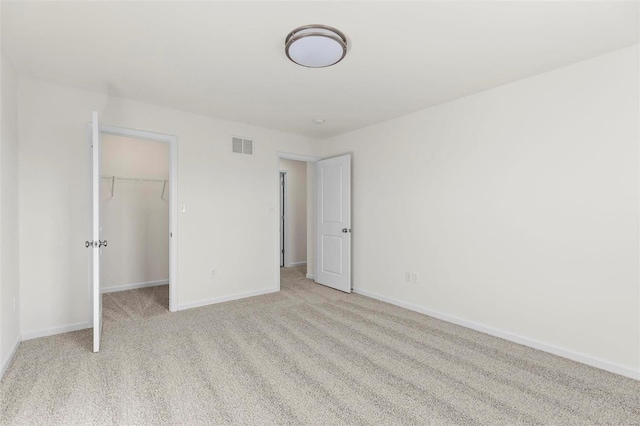 unfurnished bedroom featuring light carpet and a closet