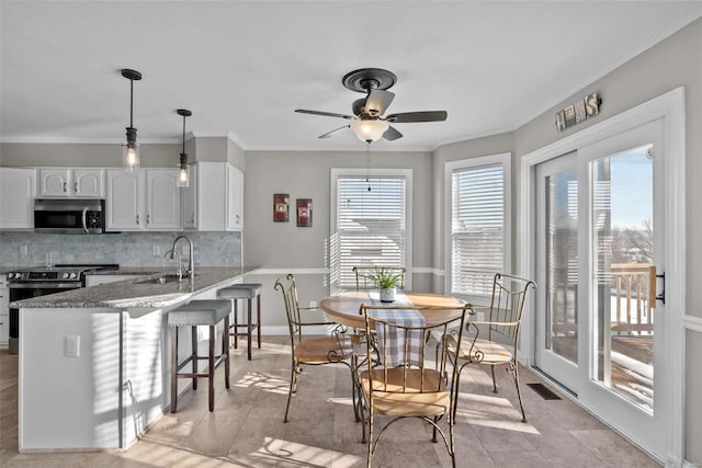 kitchen with sink, white cabinets, dark stone countertops, decorative backsplash, and appliances with stainless steel finishes