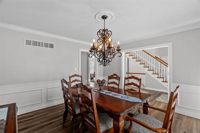 dining space featuring ornamental molding, dark hardwood / wood-style flooring, and an inviting chandelier