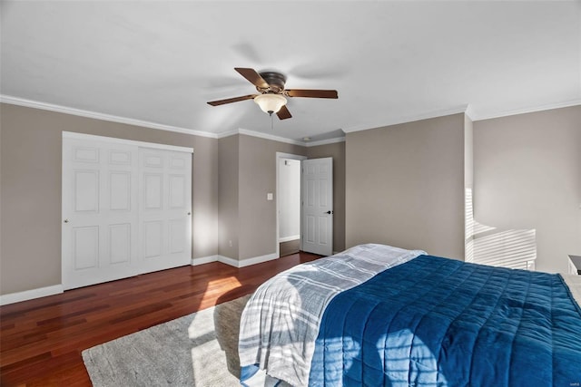 bedroom featuring dark wood-type flooring, ceiling fan, crown molding, and a closet