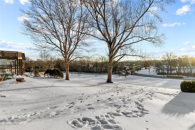 yard covered in snow featuring a playground