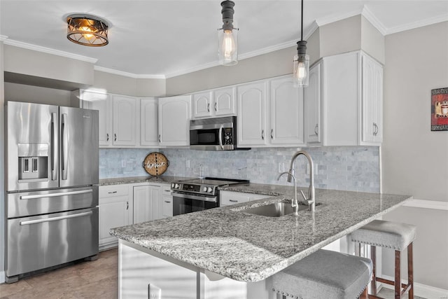 kitchen featuring appliances with stainless steel finishes, hanging light fixtures, white cabinetry, and backsplash