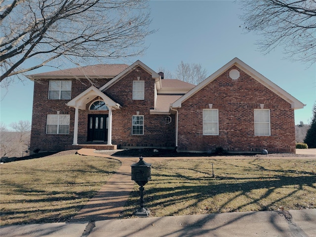 view of front facade with a front yard and brick siding