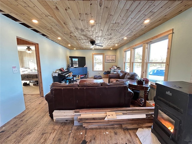 living room featuring a wood stove, wooden ceiling, and light hardwood / wood-style floors