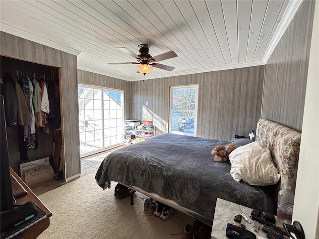 carpeted bedroom with crown molding, ceiling fan, a closet, and wooden ceiling