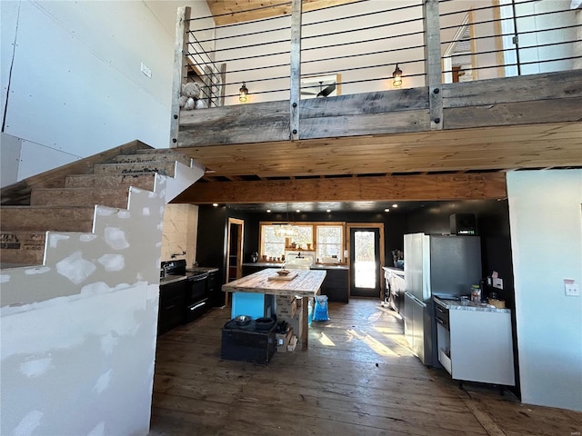 kitchen featuring dark wood-type flooring, a towering ceiling, wooden counters, and white refrigerator