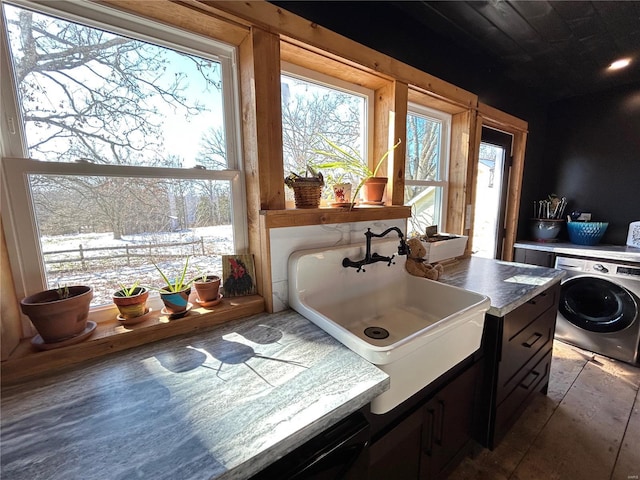 laundry area featuring a healthy amount of sunlight, washer / dryer, and sink