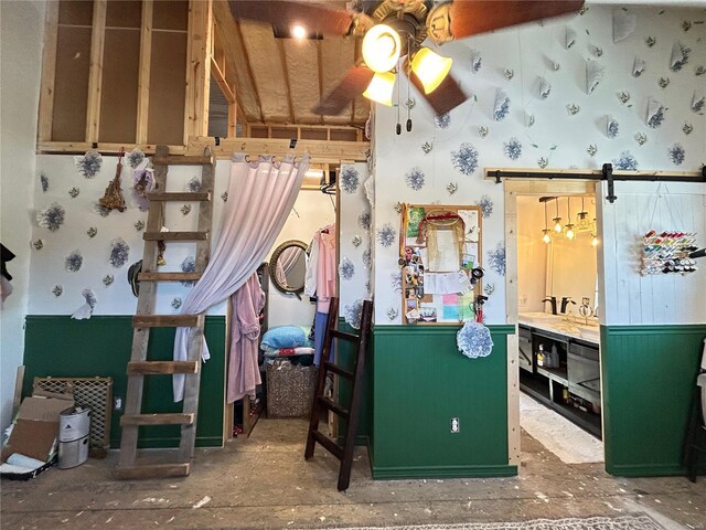 misc room with a barn door and ceiling fan