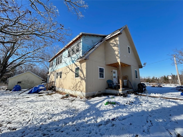 view of snow covered back of property