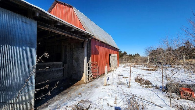 view of snowy exterior featuring an outbuilding