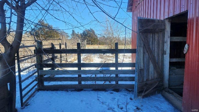 snow covered gate featuring an outdoor structure